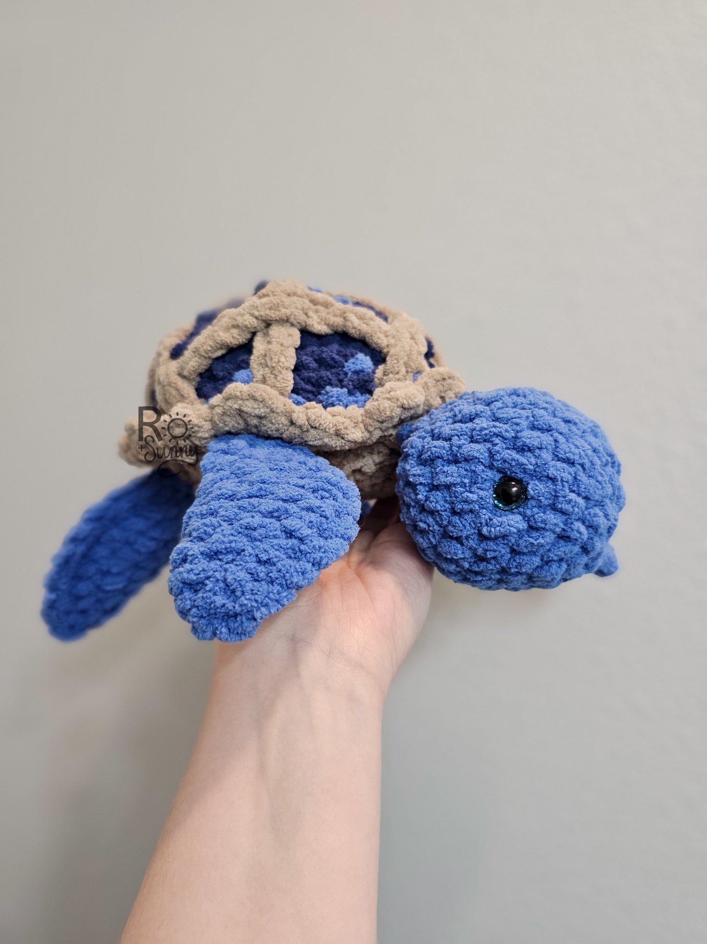 Blueberry Pie, Side Profile - Crochet sea turtle with a blue body and shell that looks like a lattice crusted blueberry pie.  Little blueberries are embroidered on the pie shell to add texture. 