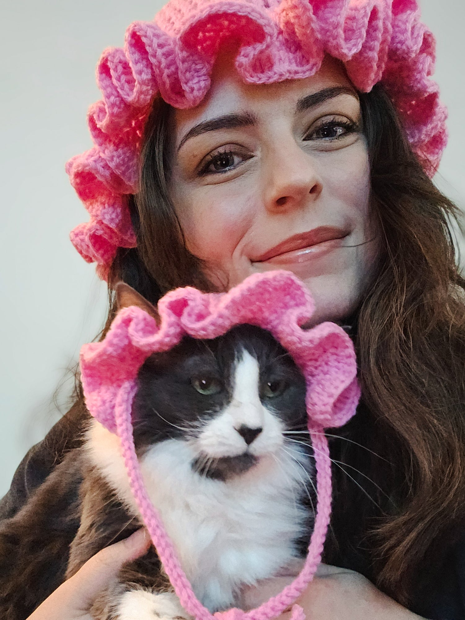 Kat (Ro & Sunny) and her cat Rogue wearing pink crochet ruffle hats.